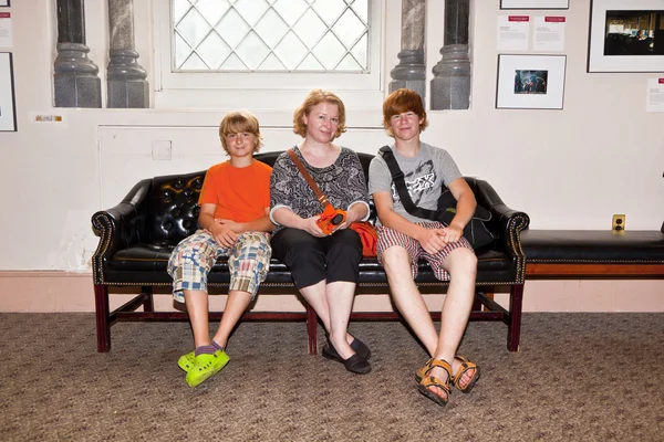 Семья, сидящая на скамейке у входа в Смитхонейскую музу — стоковое фото