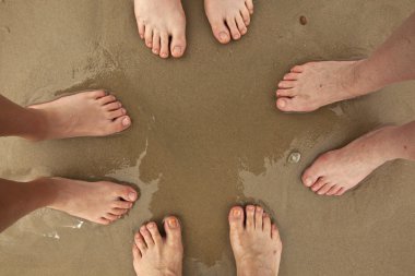 Feet of happy family at the beach clipart