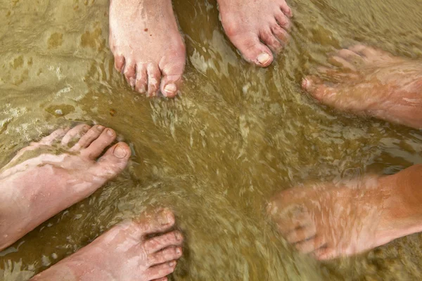 Fötter av lycklig familj på stranden — Stockfoto