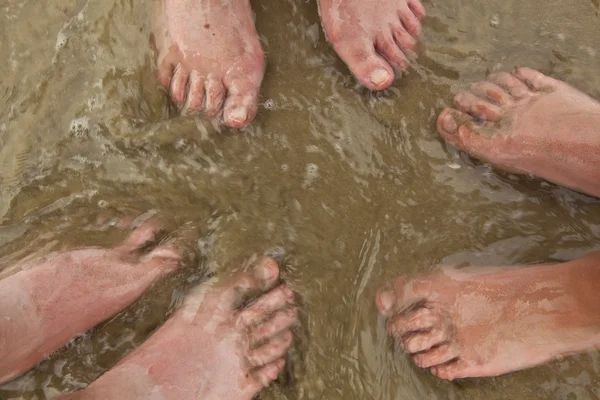 Ноги счастливой семьи на пляже — стоковое фото
