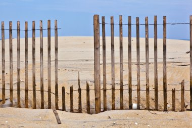 Fence for protection of the dunes at the beautiful natural beach clipart