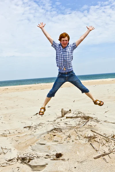 Menino gosta da bela praia e salta — Fotografia de Stock