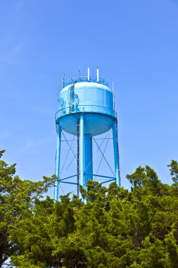 A blue watertower against a blue cloudy sky clipart