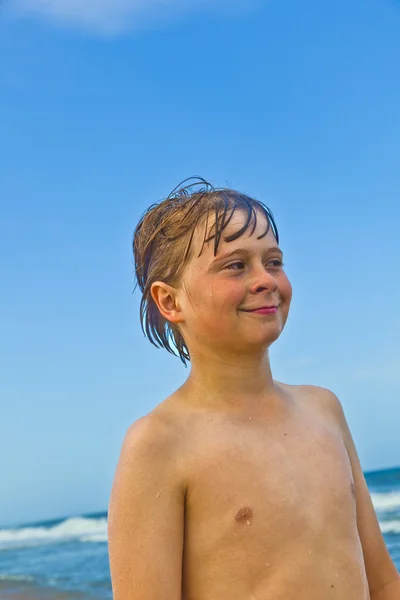 Симпатичный улыбчивый мальчик на пляже — стоковое фото