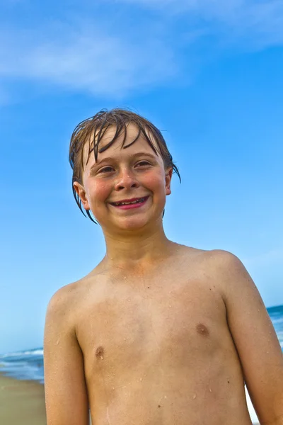 Симпатичный улыбчивый мальчик на пляже — стоковое фото