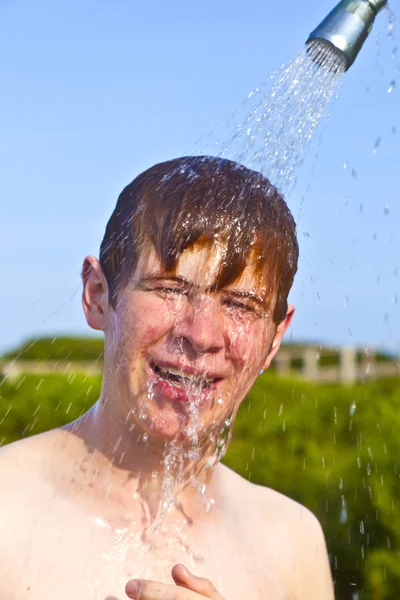 Junge hat eine Dusche am Strand — Stockfoto
