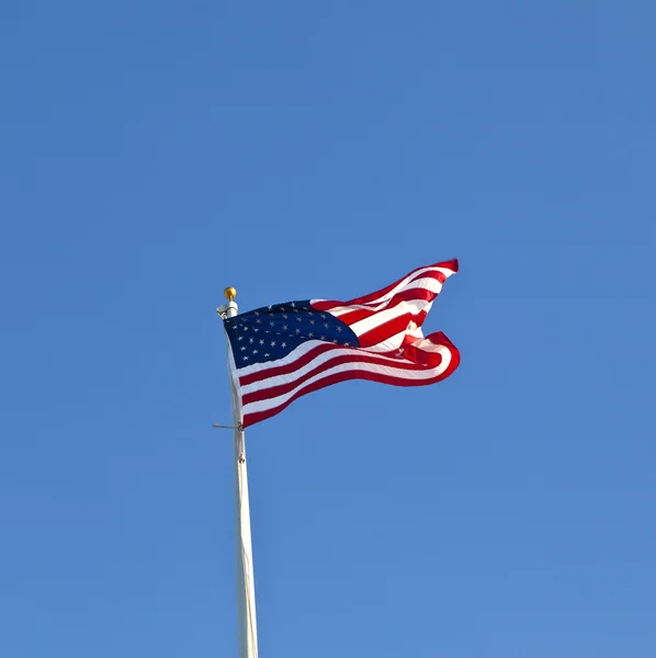 Bandera americana ondeando contra un cielo azul brillante — Foto de Stock