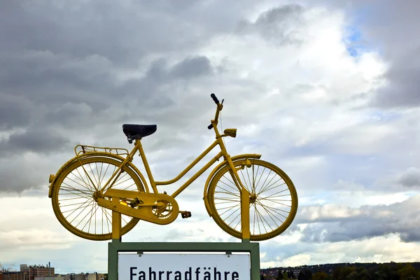 Old yellow bike on a roof as hint for a bike ferry in dark cloud — Stock Photo, Image