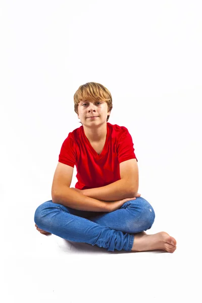 Smart boy with red shirt sitting in tailor seat at the floor — Stock Photo, Image