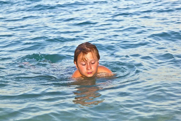 Мальчик наслаждается прекрасной водой океана — стоковое фото