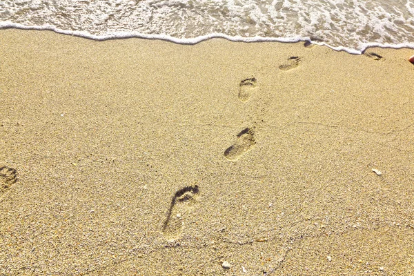 Pasos en la playa en la arena — Foto de Stock