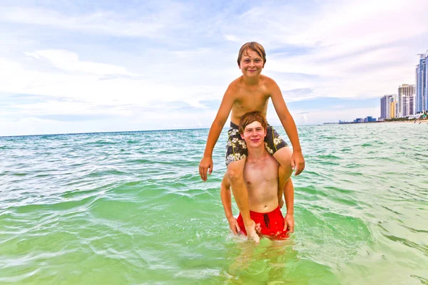 Мальчики веселятся в красивом чистом море — стоковое фото