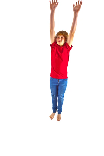 Умный мальчик в красной рубашке, прыгающий в воздухе — стоковое фото