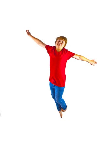 Умный мальчик в красной рубашке, прыгающий в воздухе — стоковое фото