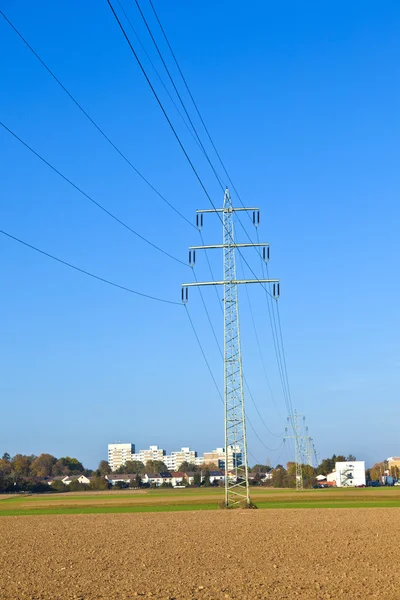 Electrical tower in field under blue sky — Stock Photo, Image