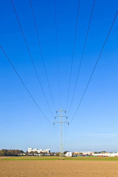Ηλεκτρικές πύργος στο πεδίο κάτω από το γαλάζιο του ουρανού — Φωτογραφία Αρχείου
