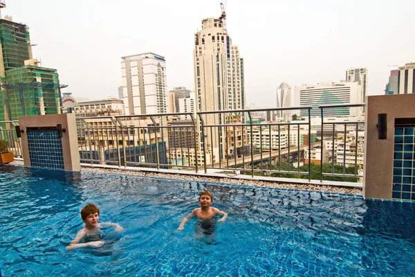 Boys are swimming in an open air pool with beautiful view to the — Stock Photo, Image