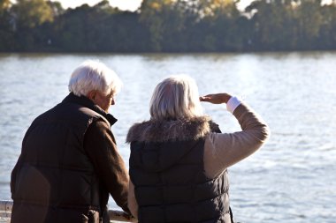 Couple watching the nature at the river clipart