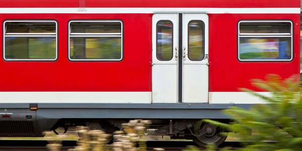 Κόκκινο βαγόνι σε κίνηση του ενός δημόσιου σιδηροδρομικό — Φωτογραφία Αρχείου