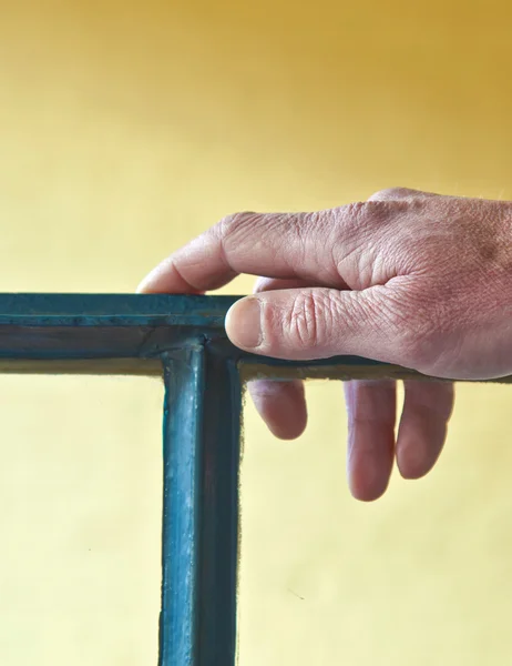 Hand met armband leunend op een raamkozijn — Stockfoto