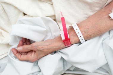 Elderly woman wearing medical arm bands clipart