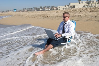 Businessman on beach working clipart