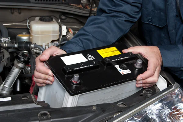 Auto mechanic replacing car battery — ストック写真