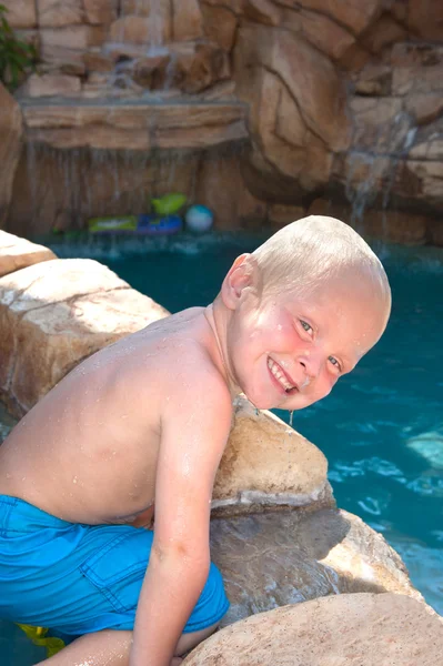 Plavovlasý chlapec hraje v bazénu — Stock fotografie