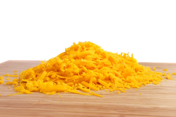 Grated cheese on cutting board — Stock Photo, Image