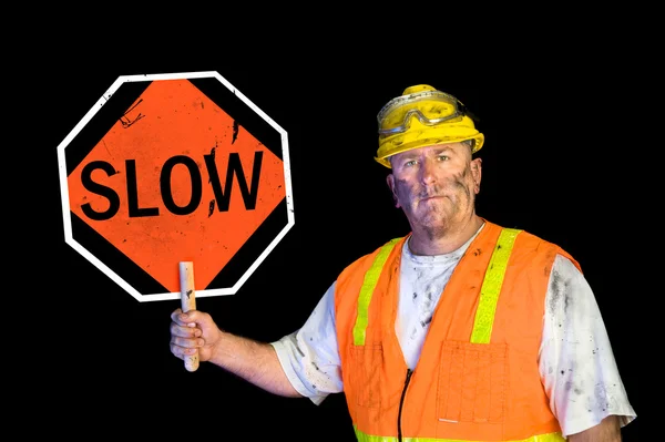 Trabalhador da construção sujo segurando sinal lento — Fotografia de Stock