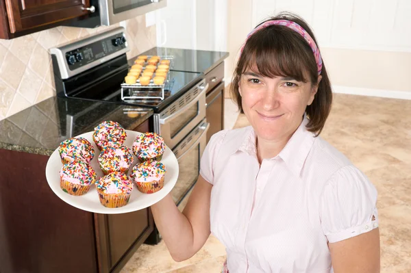 Homemaker holding plate of cupcakes — Stock Photo, Image
