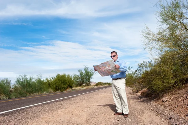 Άνθρωπος ανάγνωση χάρτη στον έρημο δρόμο — Φωτογραφία Αρχείου