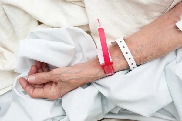 Femme âgée portant des bracelets médicaux — Photo