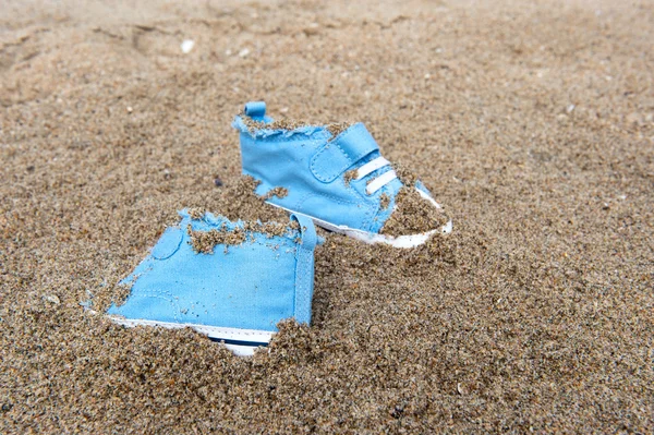 Baby shoes on beach — Stockfoto
