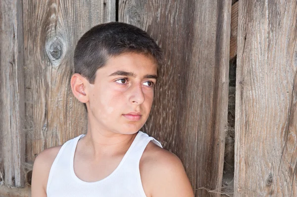 Boy against old barn wall — Stock Photo, Image