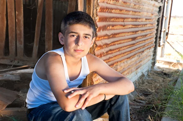 男孩坐在旧谷仓 — 图库照片