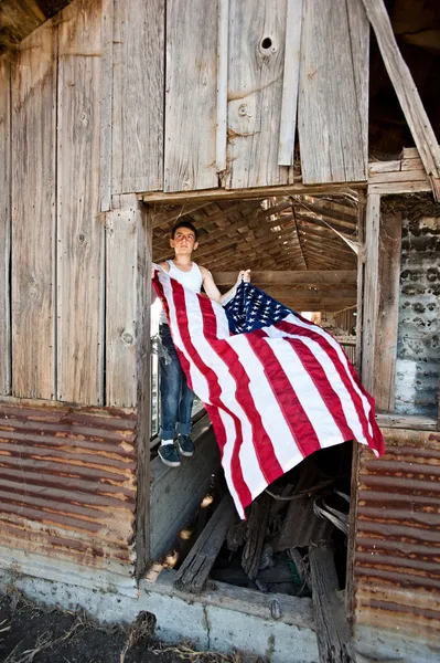 Menino pendurado bandeira americana — Fotografia de Stock