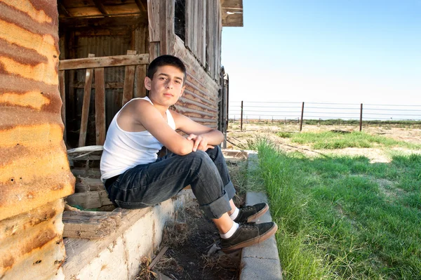 Niño sentado en el granero —  Fotos de Stock