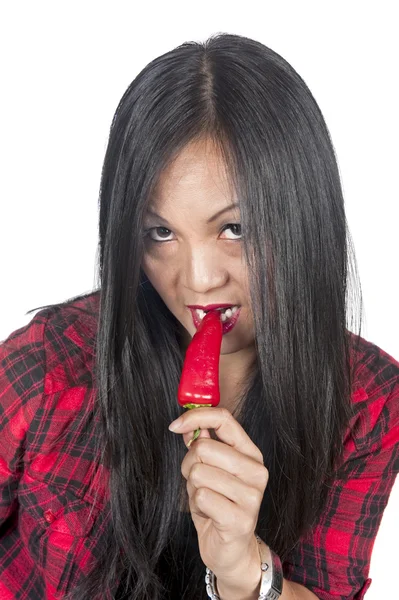 Asian woman biting red hot pepper — Stock Photo, Image