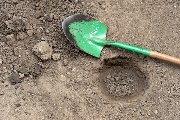 Dug hole and shovel — Stock Photo, Image