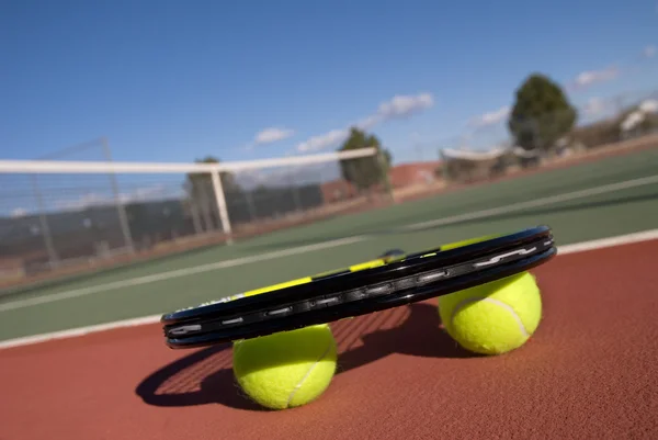 Тенісні м'ячі, корт і ракетка — стокове фото