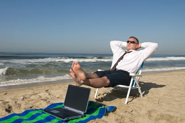 Бизнесмен на пляже расслабляющий — стоковое фото