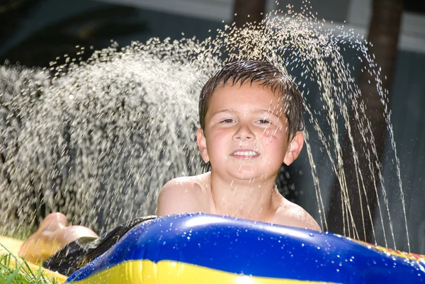 Boy on water slide — Stock Photo, Image