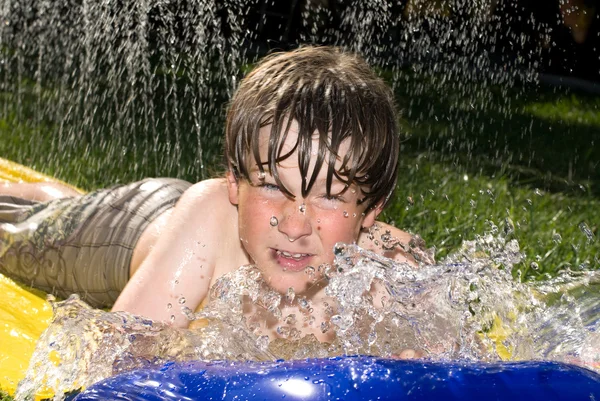 Pojke på vattenrutschbana — Stockfoto