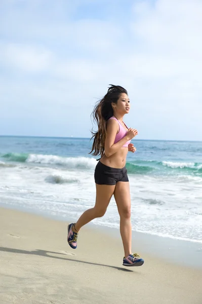 Asian woman jogging at beach Stock Photo