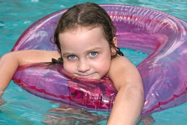 Little girl swimming in pool with float clipart