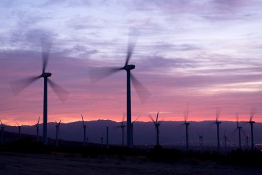 Wind power mills at sunrise clipart