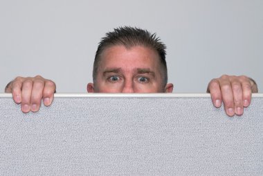 Man peering over office cubicle clipart