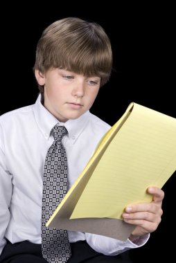 Boy in business dress reading notepad clipart