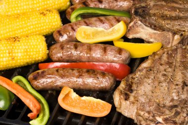 Barbecued steak, bratwurst and corn on the cob clipart